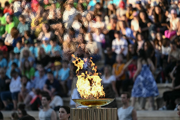 La vasque olympique brûle lors de la cérémonie de remise de la flamme olympique pour les Jeux olympiques et paralympiques d'été de Paris 2024 au stade Panathinéen d'Athènes, le 26 avril 2024.  (ARIS MESSINIS/AFP via Getty Images)