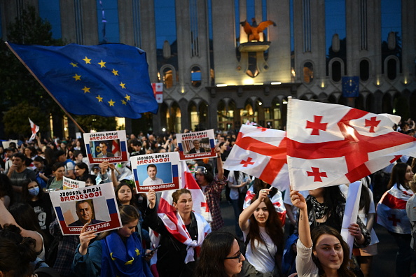 Des manifestants brandissent un drapeau de l'Union européenne, des drapeaux de la Géorgie et des pancartes à Tbilissi, le 2 mai 2024. (Photo VANO SHLAMOV/AFP via Getty Images)