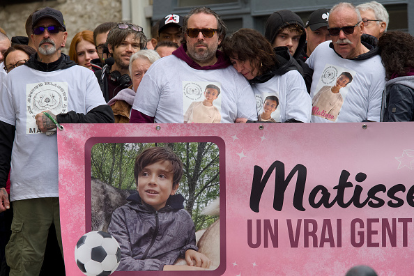De g. à dr. : Le père, la mère, derrière une banderole à son effigie, participent à une « Marche Blanche » commémorative en hommage à leur fils de 15 ans, Matisse. (Photo GUILLAUME SOUVANT/AFP via Getty Images)