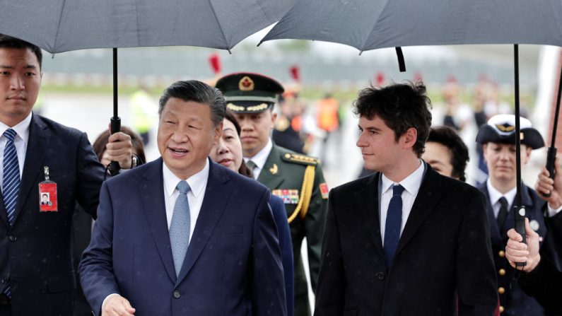 Le Premier ministre Gabriel Attal  accueille le leader chinois Xi Jinping à son arrivée pour une visite d'État officielle de deux jours, à l'aéroport d'Orly, au sud de Paris, le 5 mai 2024.(STEPHANE DE SAKUTIN/POOL/AFP via Getty Images)