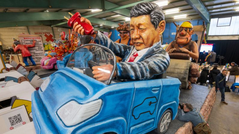 Un char représentant le président chinois Xi Jinping débranchant une voiture électrique et abandonnant les constructeurs automobiles allemands dans la salle des voitures du club du carnaval Verein 1838 e.V. en prévision du défilé du Lundi des roses, le 6 février 2024 à Mayence, en Allemagne. (Thomas Lohnes/Getty Images)