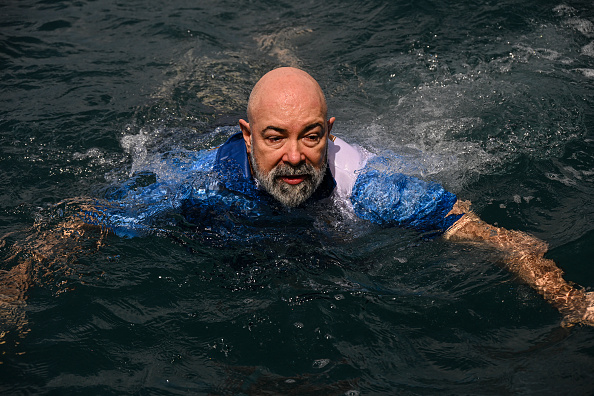 L'ingénieur aérospatial allemand Rudiger Koch, 59 ans, saute dans l'eau pour célébrer le record du monde Guinness de vivre dans l'océan à une profondeur de onze mètres au large de Puerto Lindo au Panama. (MARTIN BERNETTI/AFP via Getty Images)