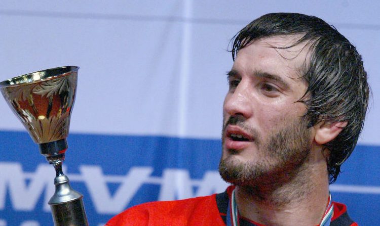 Le Russe Buvaaysa Saitiev, champion olympique et champion du monde, regarde son trophée de champion du monde sur le podium de la Laszlo Papp Sport Arena de Budapest, le 27 septembre 2005, après la finale en style libre de la catégorie des 74 kg des Championnats du monde de lutte contre le Hongrois Arpad Ritter. ( ATTILA KISBENEDEK/AFP via Getty Images)