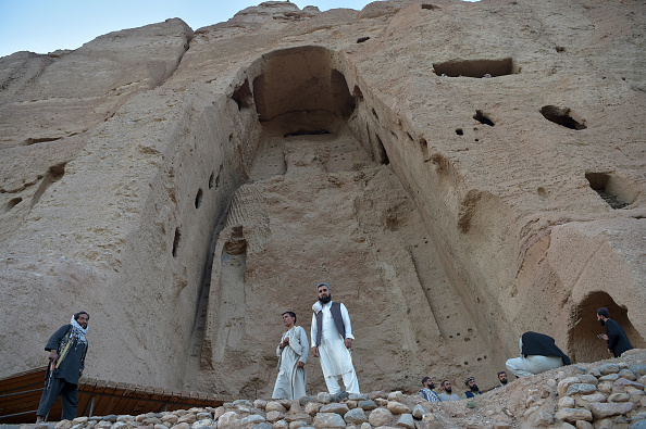 Sur cette photo prise le 13 juillet 2022, des talibans montent la garde devant le site où se trouvait autrefois la statue du Bouddha Shahmama avant sa destruction par les talibans en mars 2001, dans la province de Bamiyan. (AHMAD SAHEL ARMAN/AFP via Getty Images)