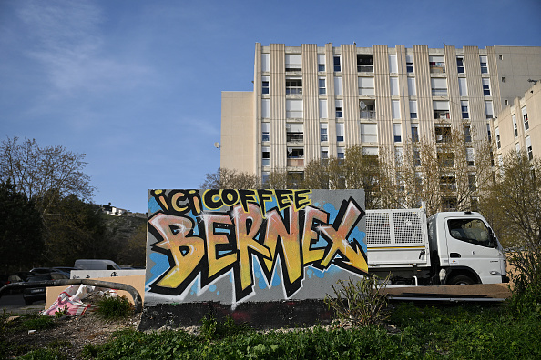 Une photo prise dans le quartier de La Castellane à Marseille, le 20 mars 2024, montre un mur peint à la main indiquant l'emplacement d'un point de deal (« Ici Café Bernex »). (NICOLAS TUCAT/AFP via Getty Images)