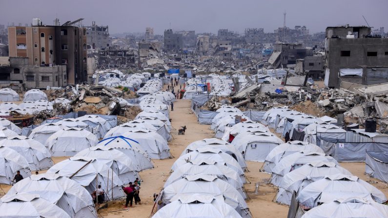 Des personnes marchent au milieu de tentes installées à côté des décombres de bâtiments détruits dans le camp de Jabalia pour les Palestiniens déplacés dans le nord de la bande de Gaza, le 8 avril 2025. (Bashar Taleb/AFP)
