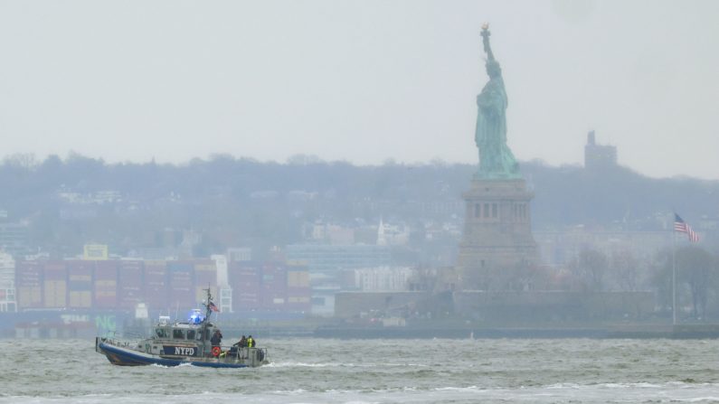 Un bateau de secours du NYPD est vu près de la Statue de la Liberté à New York après le crash d’un hélicoptère dans l’Hudson River, le 10 avril 2025. (CHARLY TRIBALLEAU/AFP via Getty Images)