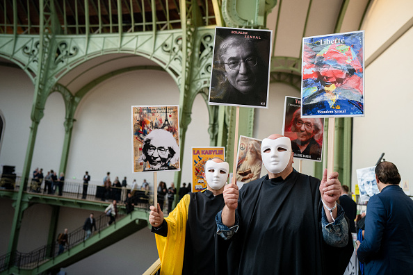 Militants demandant la libération de Boualem Sansal lors de l'édition 2025 du Festival du Livre au Grand Palais à Paris, le 10 avril 2025. (Photo STEPHANE MOUCHMOUCHE/Hans Lucas/AFP via Getty Images)