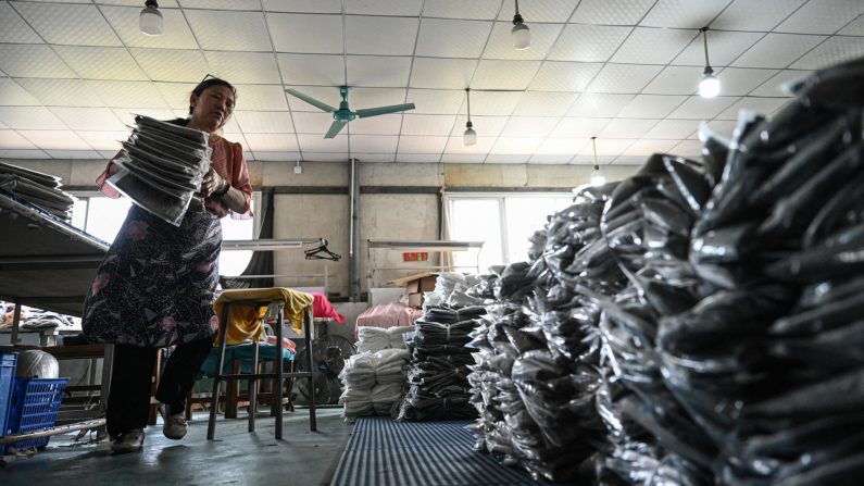 Une employée trie des vêtements pour une société de commerce en ligne dans une fabrique de vêtements à Guangzhou, dans la province chinoise du Guangdong, le 16 avril 2025. (Jade Gao / AFP via Getty Images)