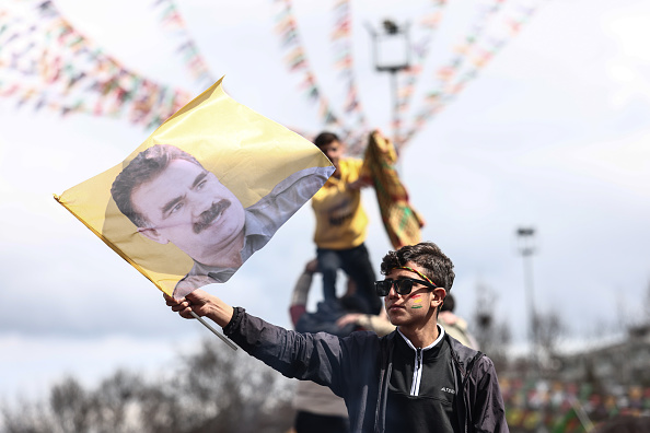 Un jeune Kurde tient une affiche du chef du groupe militant PKK emprisonné, Abdullah Ocalan, pendant les célébrations du Newroz, le 21 mars 2025 à Diyarbakir, en Turquie. (Sedat Suna/Getty Images)