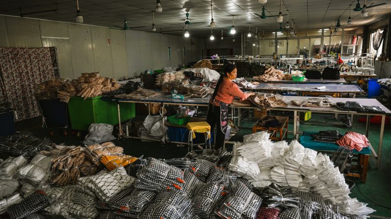 Une employée emballe des vêtements pour la société chinoise de commerce électronique Temu dans une usine de vêtements à Guangzhou, dans la province de Guangdong, dans le sud de la Chine, le 16 avril 2025. (Jade Gao/AFP via Getty Images)