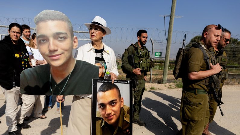 Varda Ben Baruch tient des photos de son petit-fils Edan Alexander, otage israélo-américain, alors qu'elle marche près de soldats israéliens lors d'un rassemblement de familles d'otages détenus dans la bande de Gaza à Nir Oz, près de la frontière avec la bande de Gaza, à Nir Oz, en Israël, le 20 avril 2025. (Amir Levy/Getty Images)