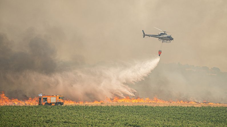 Un hélicoptère israélien de lutte contre les incendies déverse de l'eau sur l'un des points chauds des incendies de forêt qui brûlent autour de Jérusalem en Israël, le 30 avril 2025. (ORI AVIRAM/Middle East Images/AFP via Getty Images)