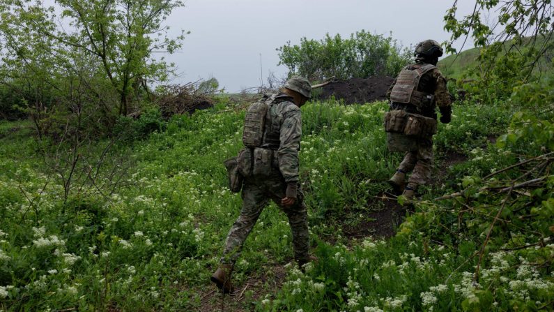 Des instructeurs militaires ukrainiens du 24e bataillon d'assaut séparé Aidar marchent dans un lieu tenu secret dans la région de Dnipropetrovsk, le 9 mai 2025, au milieu de l'invasion russe de l'Ukraine. (TETIANA DZHAFAROVA/AFP via Getty Images)