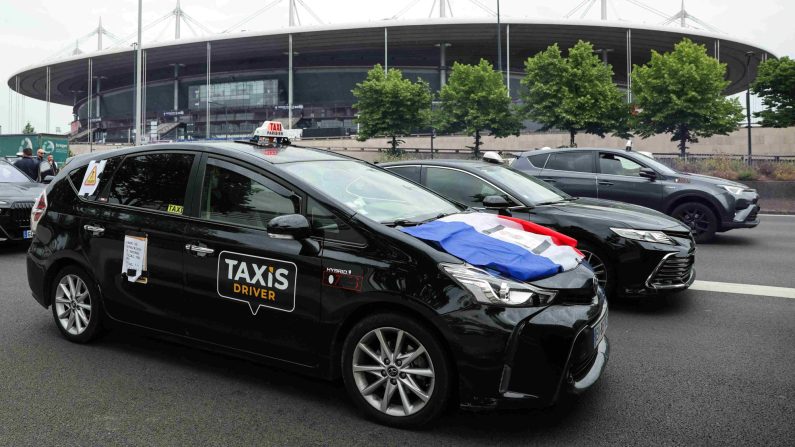 Des taxis manifestent à Saint-Denis, ralentissant l'A1 près du Stade de France, pour protester contre la réforme du transport médical et la concurrence des VTC, le 21 mai 2025. (THOMAS SAMSON/AFP via Getty Images)