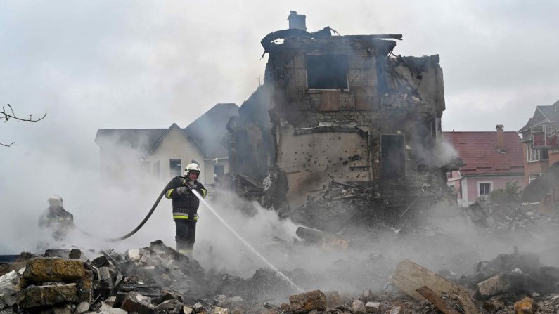 Des pompiers éteignent un incendie dans des maisons privées endommagées à la suite d'une attaque russe dans la région de Kiev, le 25 mai 2025, dans le contexte de l'invasion russe en Ukraine. (SERGEI SUPINSKY/AFP via Getty Images)