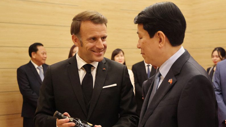 Emmanuel Macron offre une bouteille de cognac au Président vietnamien Luong Cuong lors d'un dîner d'État au Centre international des congrès à Hanoï, le 26 mai 2025. (LUDOVIC MARIN/AFP via Getty Images)