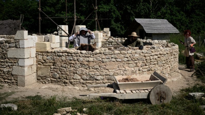 Des participants travaillent sur le chantier d'une « cathédrale » gothique utilisant des techniques médiévales, le 16 mai 2025 à La Lande-de-Fronsac, près de Bordeaux. (PHILIPPE LOPEZ/AFP via Getty Images) 