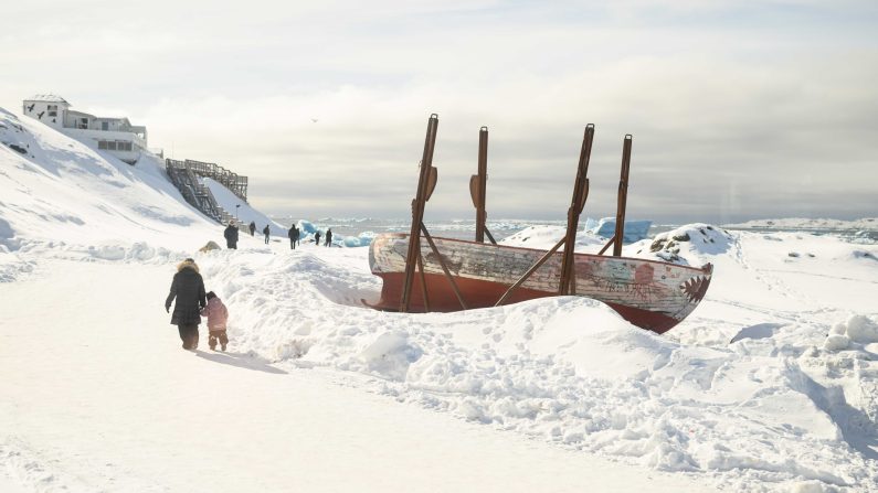 Des touristes explorent les gros morceaux de glace échoués sur la plage le 30 mars 2025 à Nuuk, au Groenland. (Leon Neal/Getty Images)