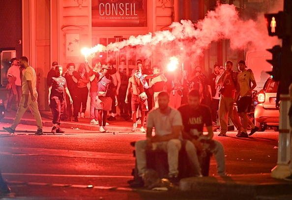 Des supporters du Paris Saint-Germain (PSG) se rassemblent en brandissant des fumigènes dans une rue de Paris, tôt le 1er juin 2025, lors des célébrations suivant leur victoire 5-0 en finale de la Ligue des champions de l’UEFA contre l’Inter Milan, disputée à Munich. (Photo LOU BENOIST/AFP via Getty Images)