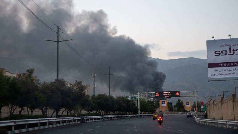 De la fumée s'élève des décombres d'un bâtiment des médias d'État iraniens à Téhéran après une frappe aérienne israélienne le 16 juin 2025. (NIKAN/Middle East Images/AFP via Getty Images)