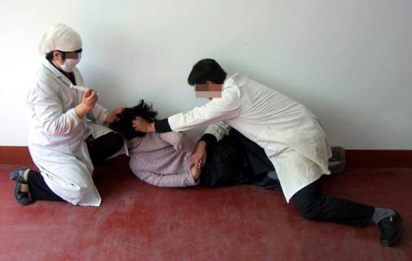 Re-enactment of a victim being forcibly injected